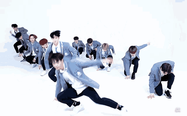 a group of young men are jumping in the air and one of them has a blue ribbon on his chest