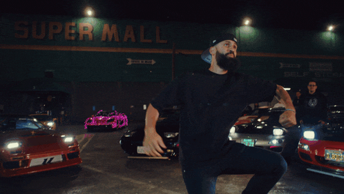 a man dancing in front of a super mall sign