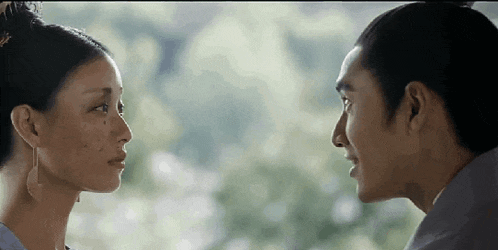 a man and a woman are looking at each other in a close up of their faces .