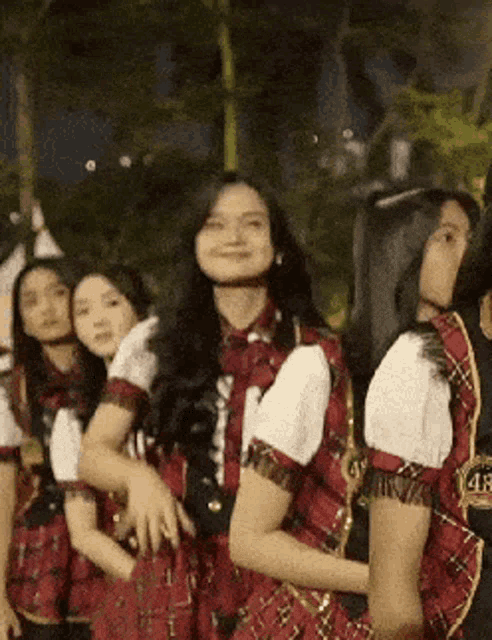 a group of young women are standing next to each other wearing plaid dresses