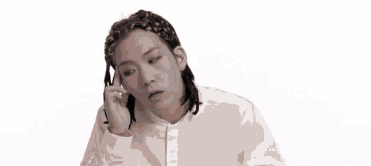 a man with dreadlocks is talking on a cell phone .