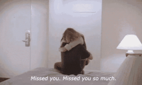 a woman hugging a man on a bed with the words " missed you missed you so much " on the bottom