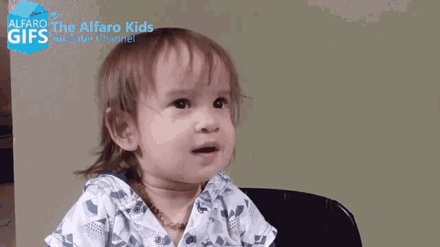 a baby is sitting in front of a sign that says alfaro kids
