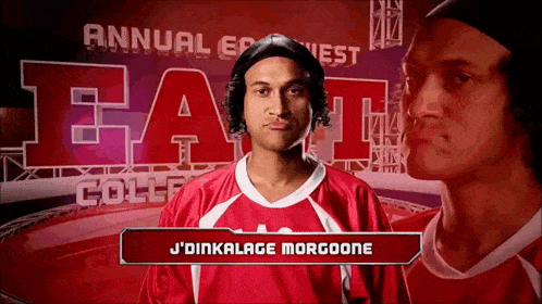 a man in a red shirt is standing in front of a sign that says j'dinkalage morgoone