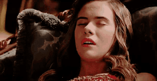 a woman with her eyes closed is laying on a chair