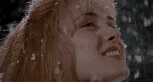 a close up of a woman 's face with snow falling