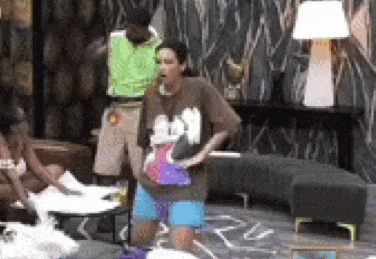 a woman in a mickey mouse shirt is standing in a room