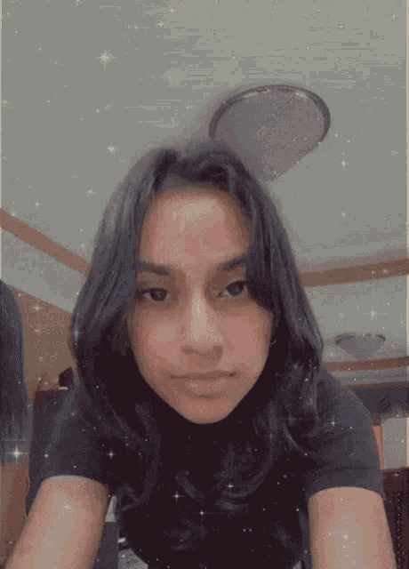 a girl with long black hair is making a face
