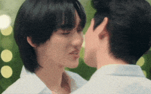 a man and a woman are kissing each other in front of a green background .