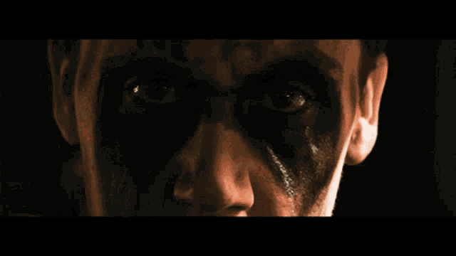 a close up of a man 's face with a lot of black paint on it