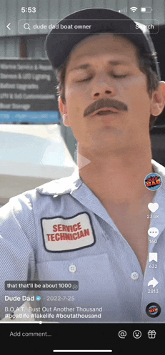 a man with a mustache wearing a service technician patch