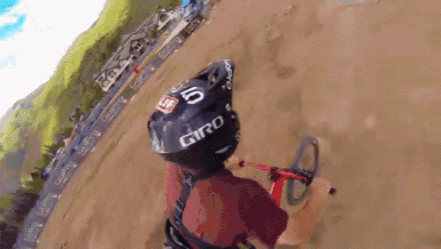 a person wearing a giro helmet is riding a bike on a dirt track