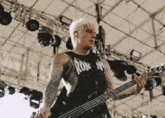 a man playing a guitar with a tank top that says rdk ny on it