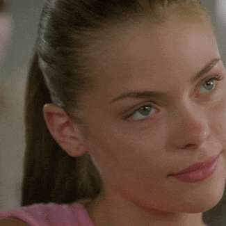 a close up of a woman 's face with a pink top on
