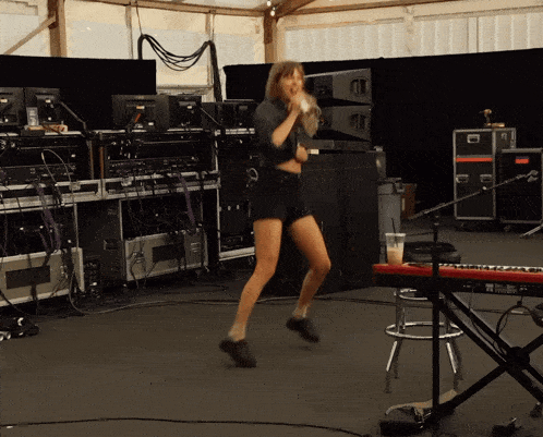a woman is singing into a microphone in front of a keyboard that says yamaha