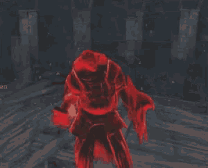 a man in a red suit is standing in a dark room in a video game .