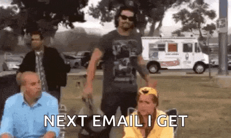 a group of people are standing in a park and one of them is sitting in a chair with the words next email i get .