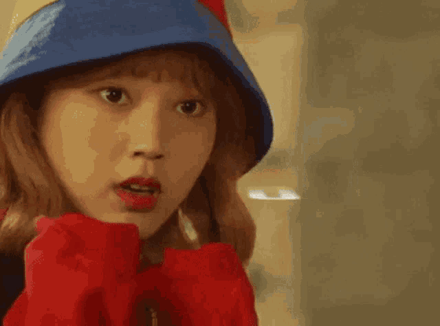 a close up of a woman wearing a colorful hat and a red jacket .
