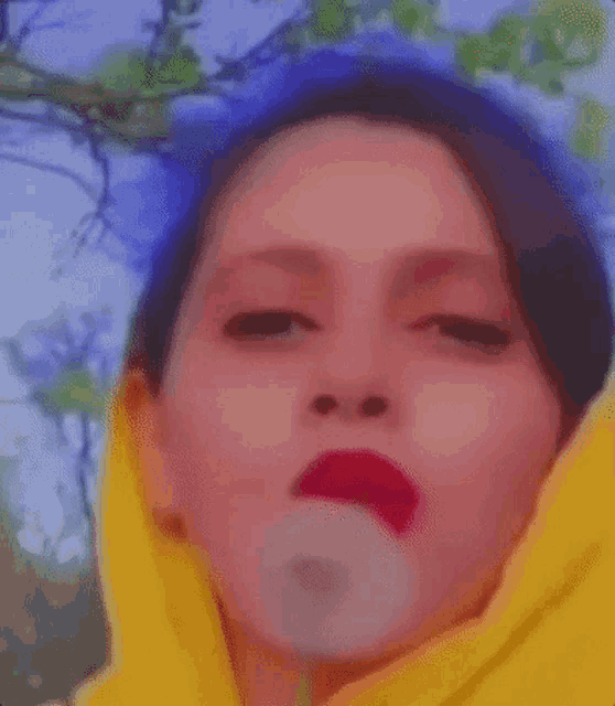 a close up of a woman 's face with red lipstick and a yellow scarf .