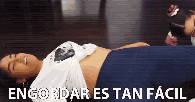 a woman laying on the floor with the words " engordar es tan facil " written below her