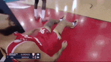 a basketball player with the number 16 on his jersey is laying on the floor during a game .