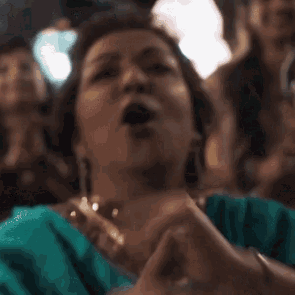 a woman in a blue and gold dress is covering her face