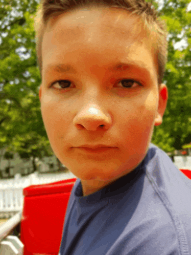 a young boy wearing a blue shirt that says tommy hilfiger