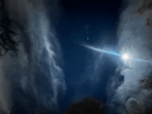 a bright light shines through the clouds in the sky