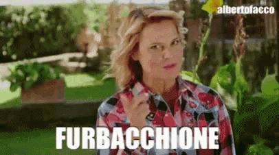 a woman in a plaid shirt is talking on a cell phone and the word furbacchione is on the bottom of the screen .