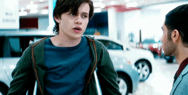 a young man with crutches is talking to another man