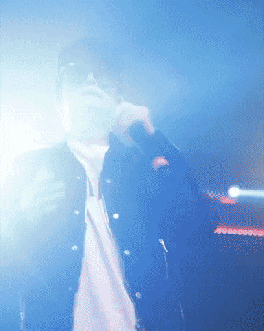 a man singing into a microphone in a dark room