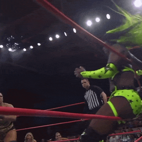a woman in a neon green outfit is wrestling in a wrestling ring
