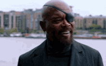 a man with a beard and eye patch is smiling .