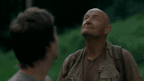 a man with his eyes closed looks up at something