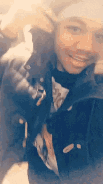 a person wearing a black jacket and a white headband is smiling
