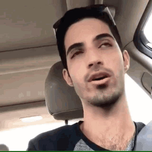 a man with a beard is sitting in the back seat of a car .