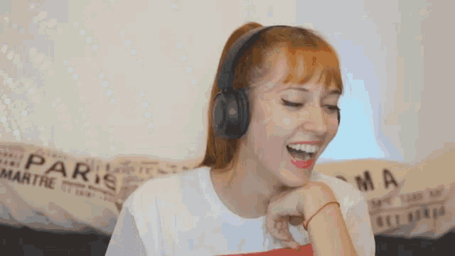 a woman wearing headphones and a white shirt with paris on it