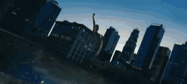 a statue of liberty stands in the middle of a city skyline
