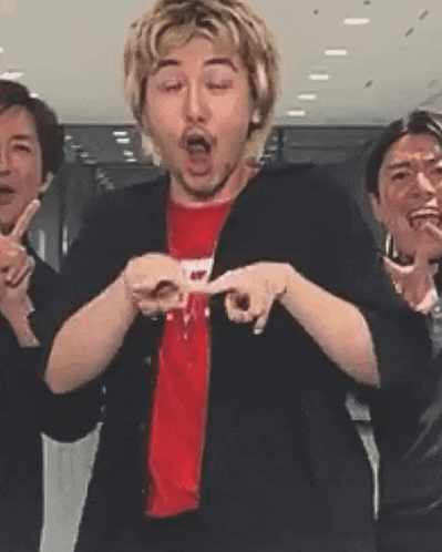 a group of men are standing next to each other making funny faces and making peace signs .