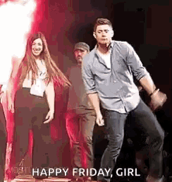 a man and a woman are dancing on a stage in front of a fire .