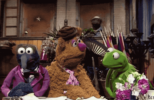 a group of sesame street characters sitting around a table including kermit the frog