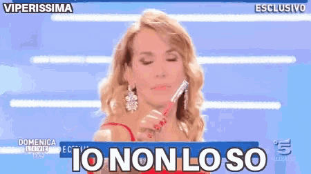a woman is holding a pen in her hand and says io non lo so .