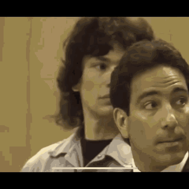 a man is standing next to a woman in a courtroom .
