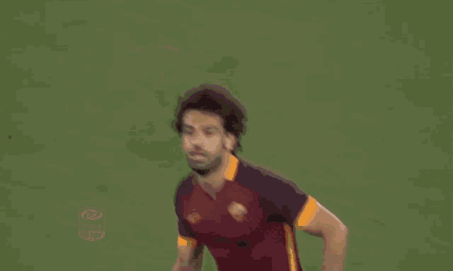 a soccer player wearing a maroon and orange jersey with the word tim on it