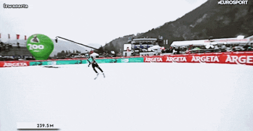 a person is skiing on a snowy slope with a banner that says argeta on it