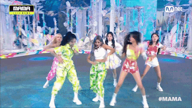a group of women are dancing on a stage in front of a sign that says mama .
