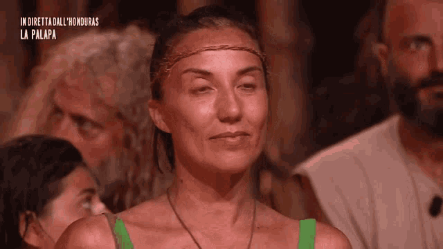 a woman in a green tank top is looking at something