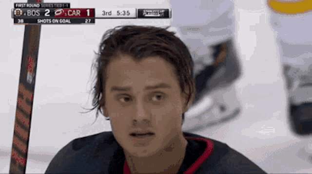 a hockey player is looking at the scoreboard which says 3rd at the top