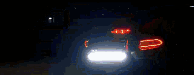 a car 's headlights are shining brightly in the night