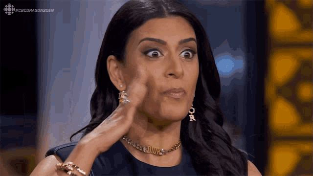 a woman wearing a dior necklace is making a face
